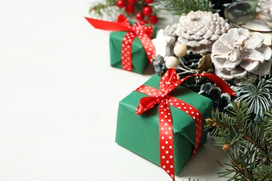 Photo of Green Christmas gift boxes with fir tree branches on white wooden table