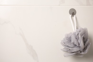 Photo of Grey shower puff hanging in bathroom, space for text