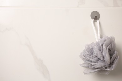 Grey shower puff hanging in bathroom, space for text