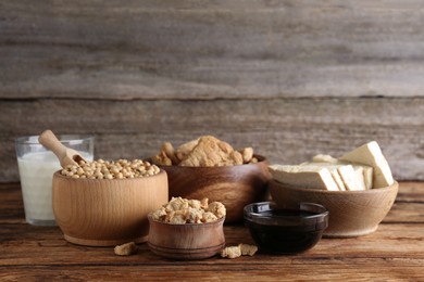 Photo of Different natural soy products on wooden table, space for text