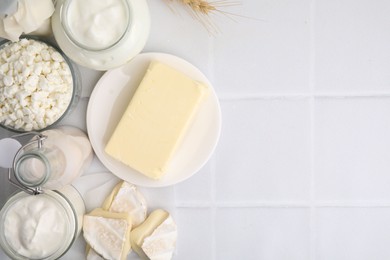 Different dairy products on white tiled table, flat lay. Space for text