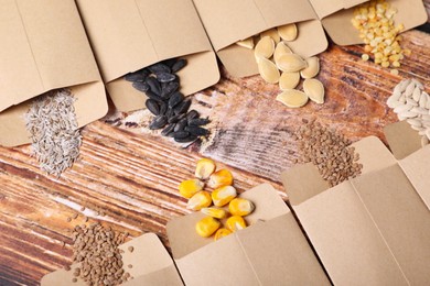 Many different vegetable seeds on wooden table, flat lay