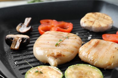 Photo of Cooking fresh squid tubes with vegetables and mushroom on grill pan, closeup