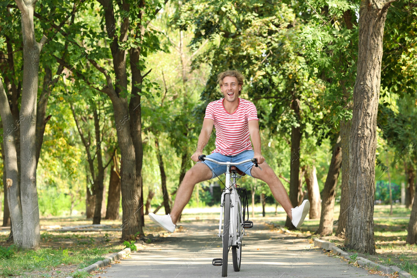 Photo of Handsome man riding bicycle in park on sunny day