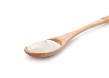 Wooden spoon with sour cream on white background