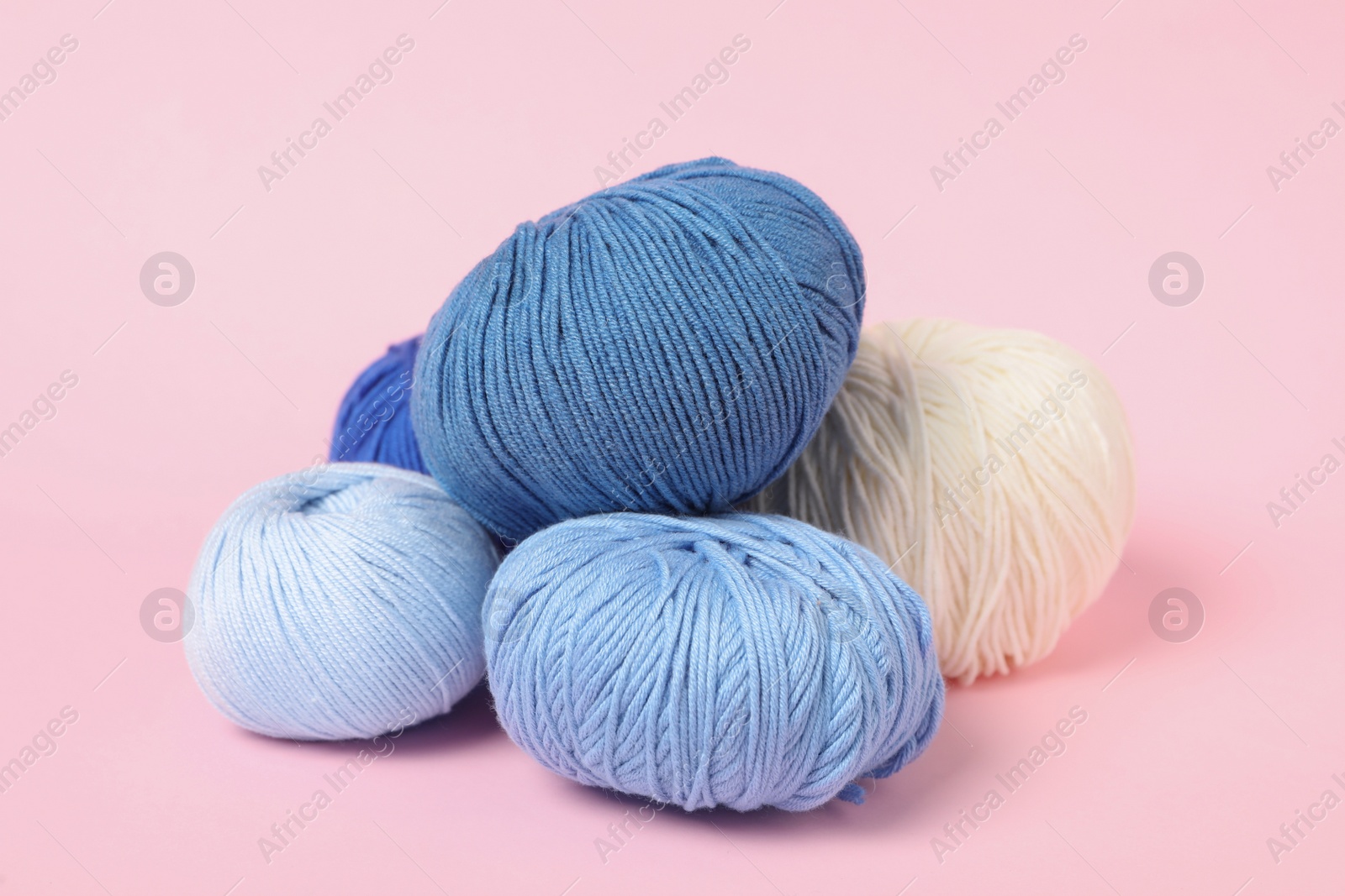 Photo of Soft colorful woolen yarns on pink background