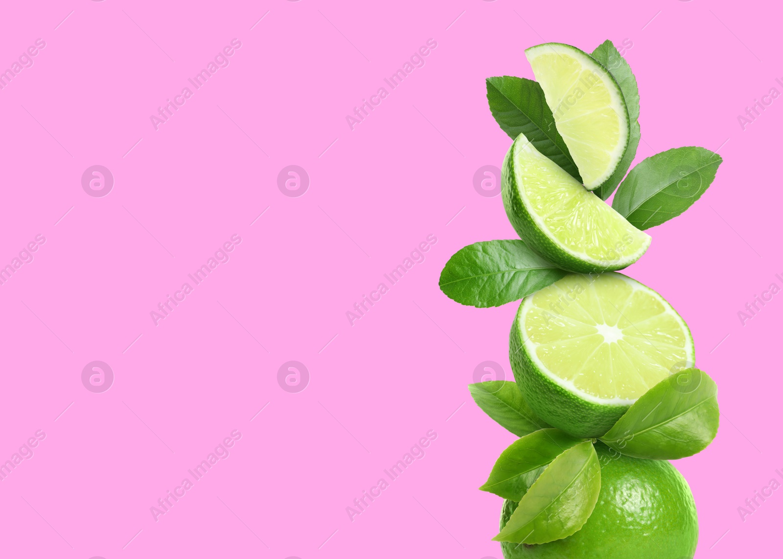 Image of Stacked cut and whole limes with green leaves on pink background, space for text