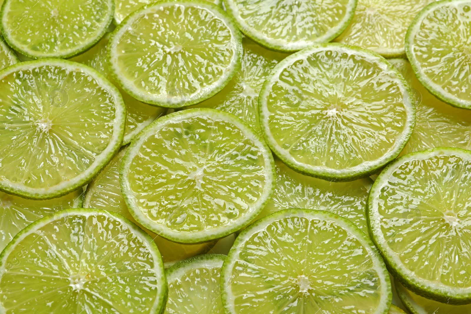 Photo of Juicy lime slices as background. Citrus fruit