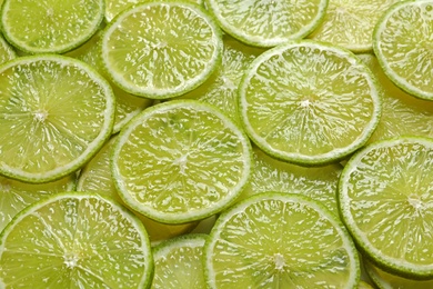 Juicy lime slices as background. Citrus fruit