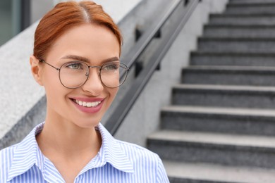 Portrait of beautiful woman in glasses outdoors, space for text