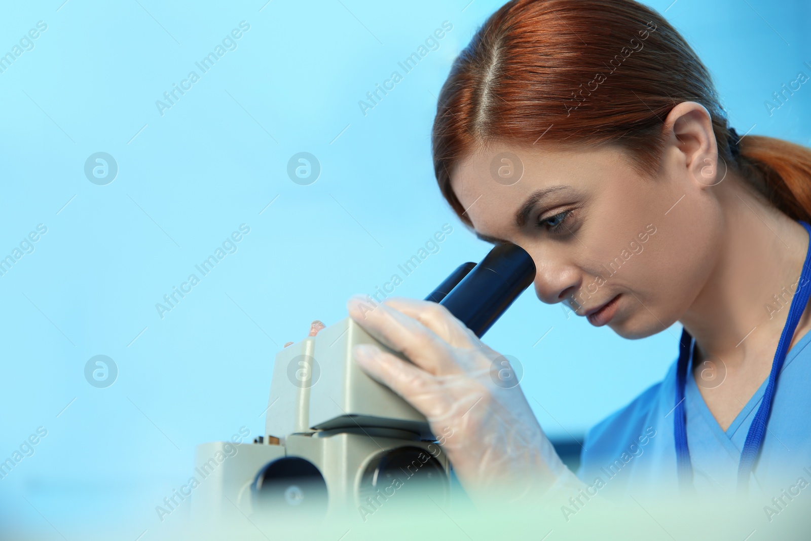 Photo of Female scientist using microscope in chemistry laboratory, space for text