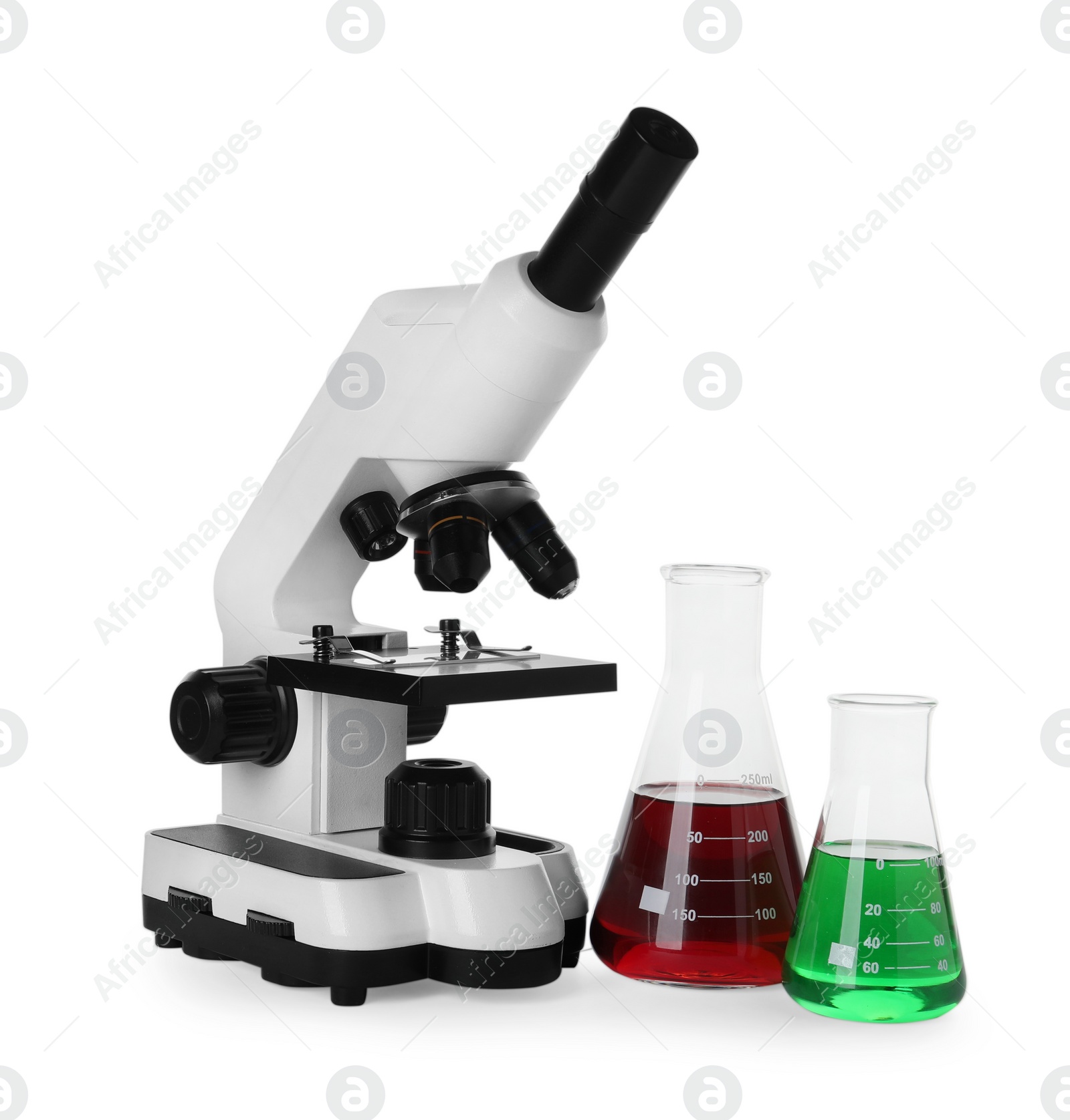 Photo of Laboratory glassware with colorful liquids and microscope isolated on white