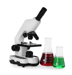 Laboratory glassware with colorful liquids and microscope isolated on white