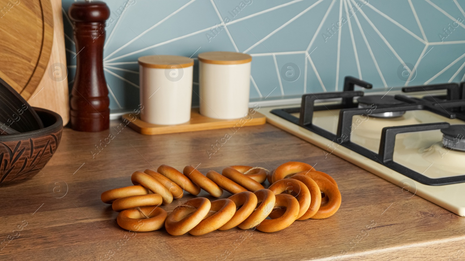Photo of Bunch of delicious ring shaped Sushki (dry bagels) on wooden table in kitchen