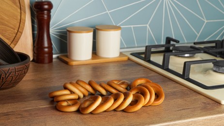 Photo of Bunch of delicious ring shaped Sushki (dry bagels) on wooden table in kitchen