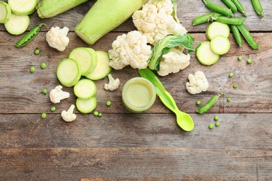 Flat lay composition with baby food and ingredients on wooden background