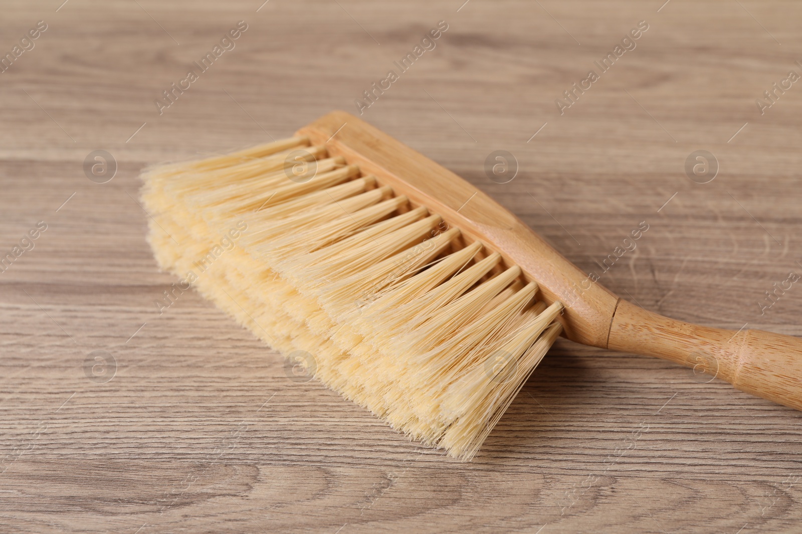 Photo of One cleaning brush on wooden table, closeup