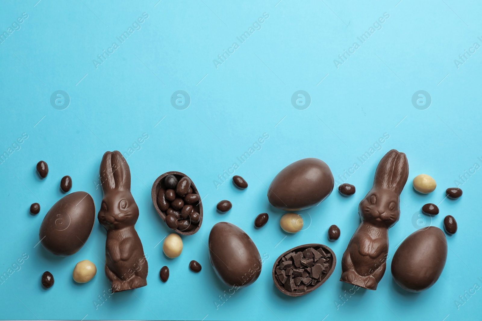 Photo of Tasty chocolate Easter eggs on color background, top view with space for text