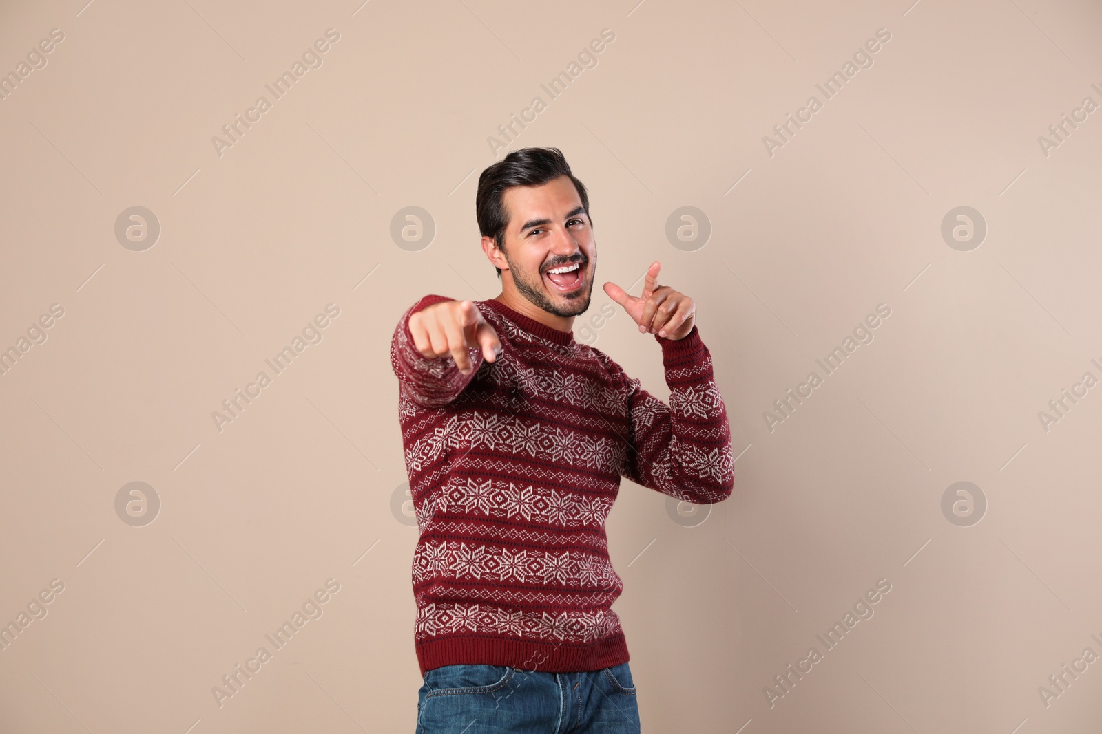 Photo of Portrait of happy man in Christmas sweater on beige background