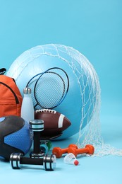 Photo of Many different sports equipment on light blue background