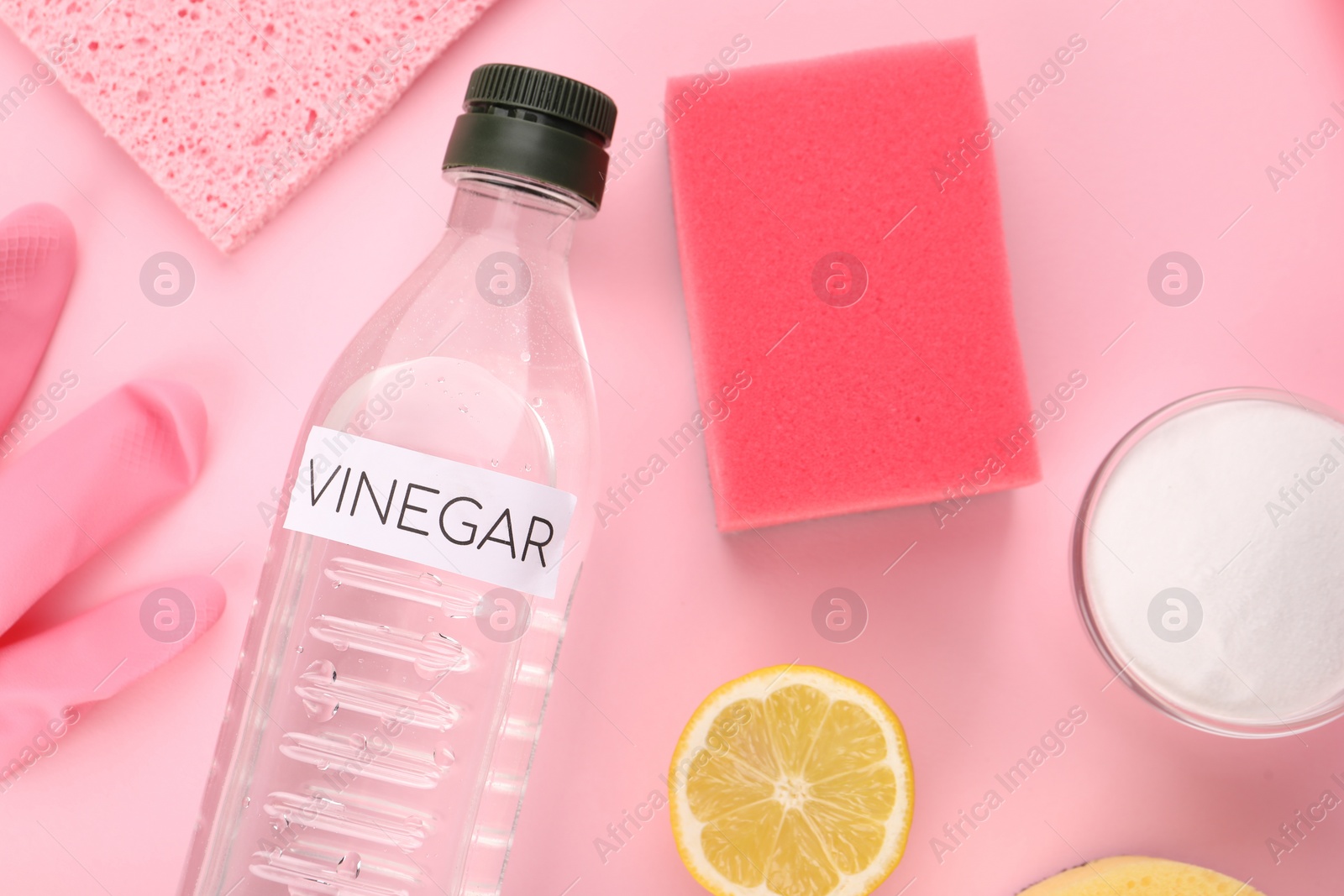 Photo of Eco friendly natural cleaners. Flat lay composition with bottle of vinegar on pink background