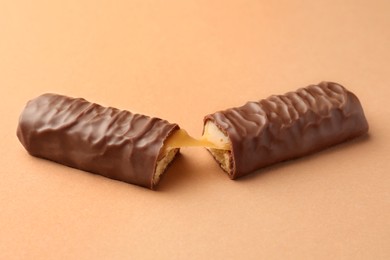 Pieces of chocolate bar with caramel on beige background