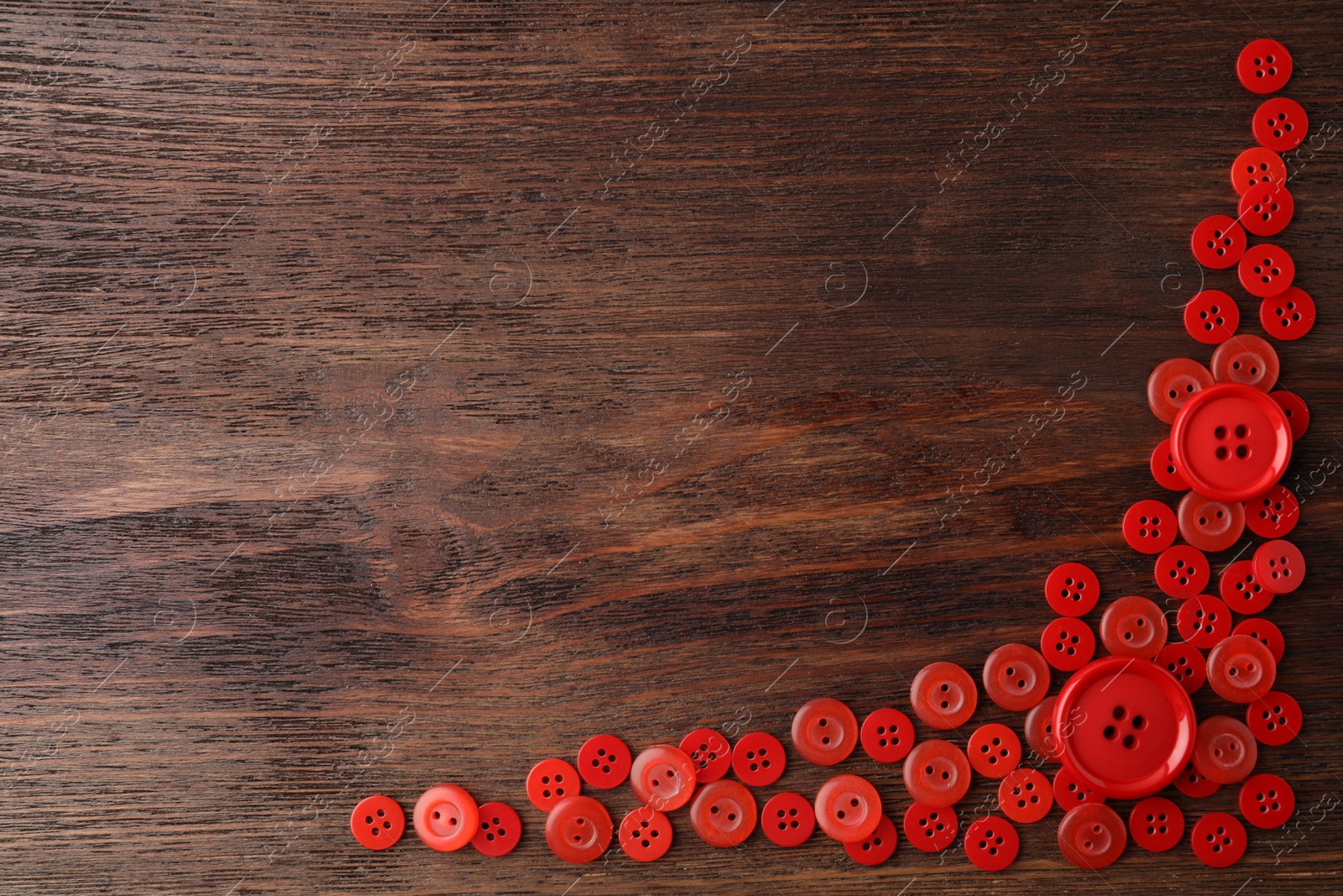 Photo of Many red sewing buttons on wooden background, flat lay. Space for text