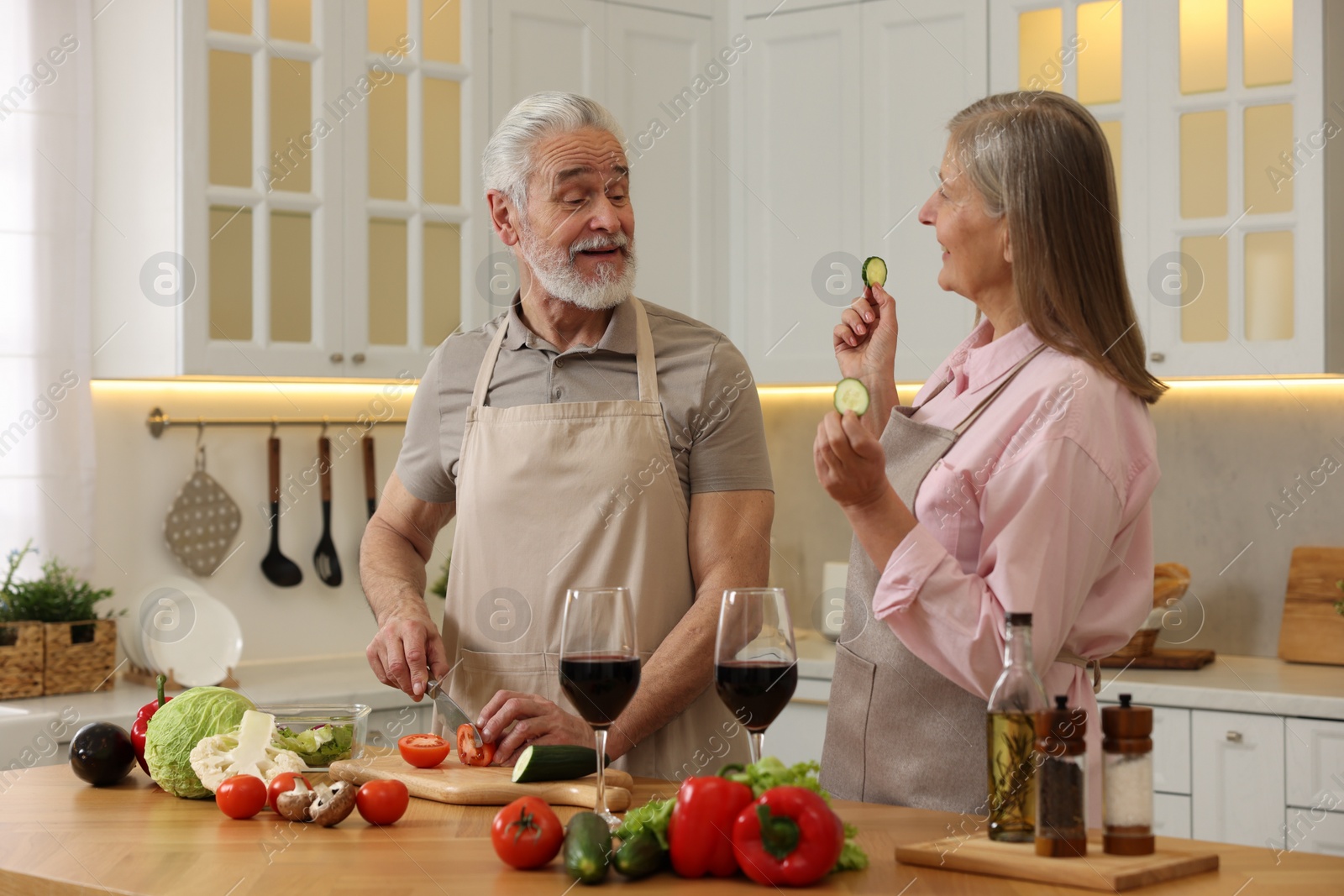 Photo of Happy senior couple cooking together in kitchen