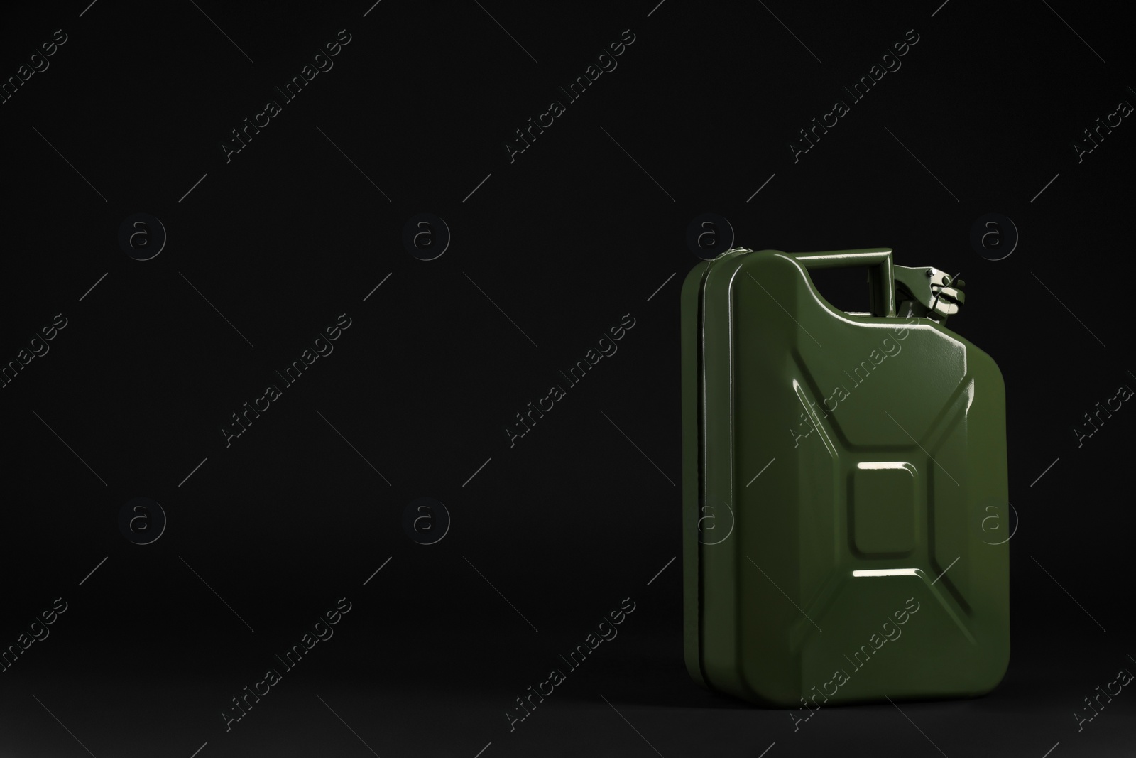 Photo of New khaki metal canister on black background. Space for text