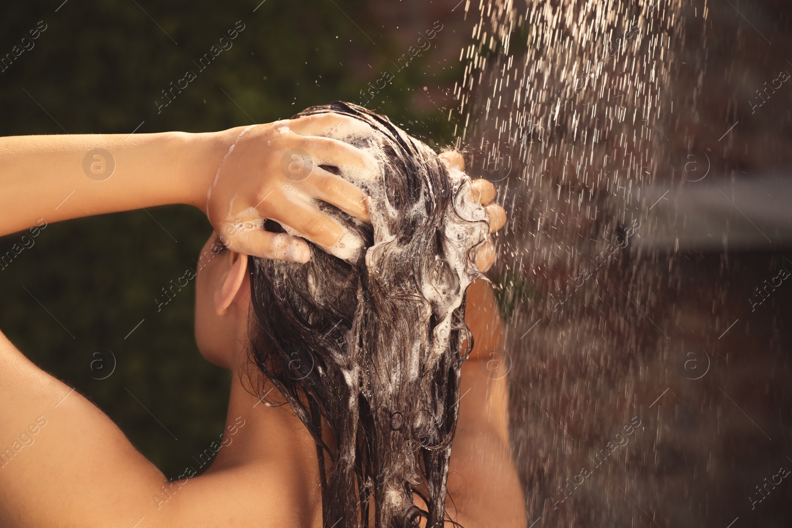 Photo of Woman washing hair in outdoor shower on summer day, closeup