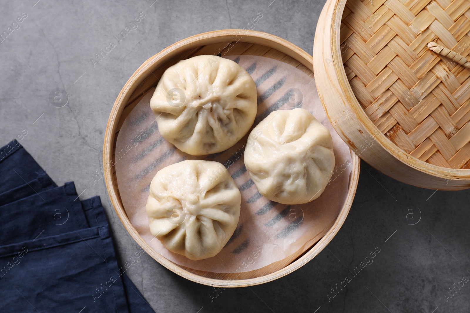 Photo of Delicious bao buns (baozi) on grey table, top view