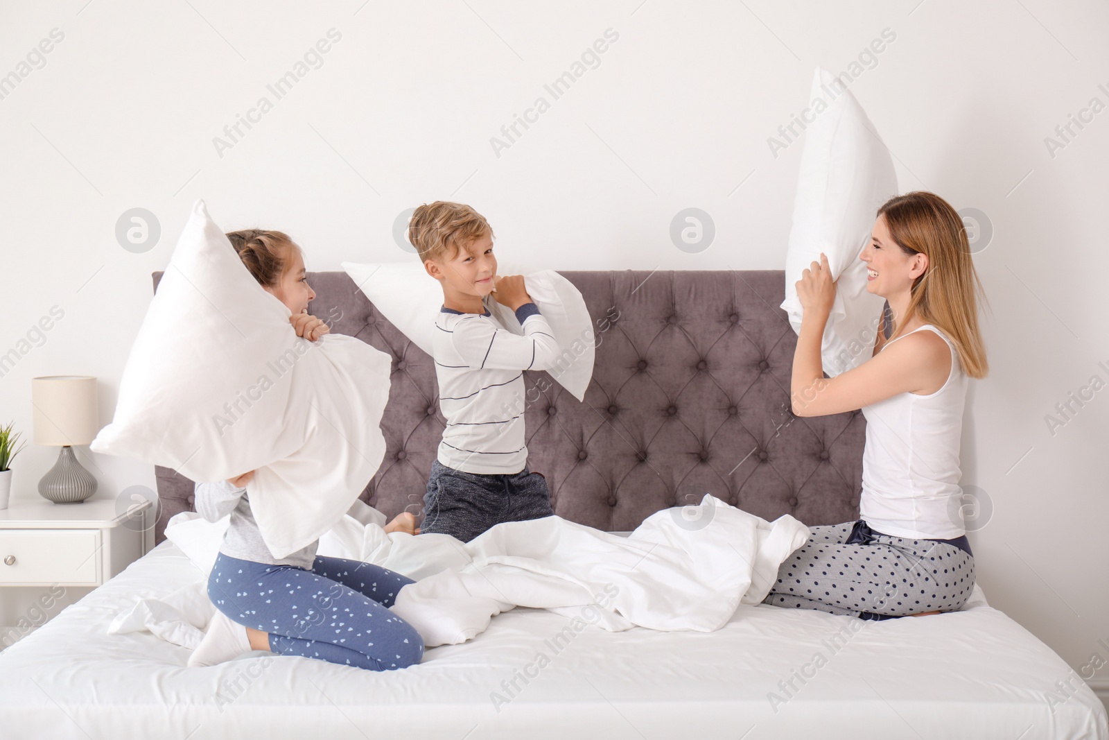 Photo of Woman playing with children in bedroom. Happy family