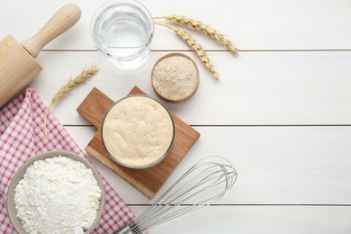 Photo of Leaven, flour, water, rolling pin, whisk and ears of wheat on white wooden table, flat lay. Space for text