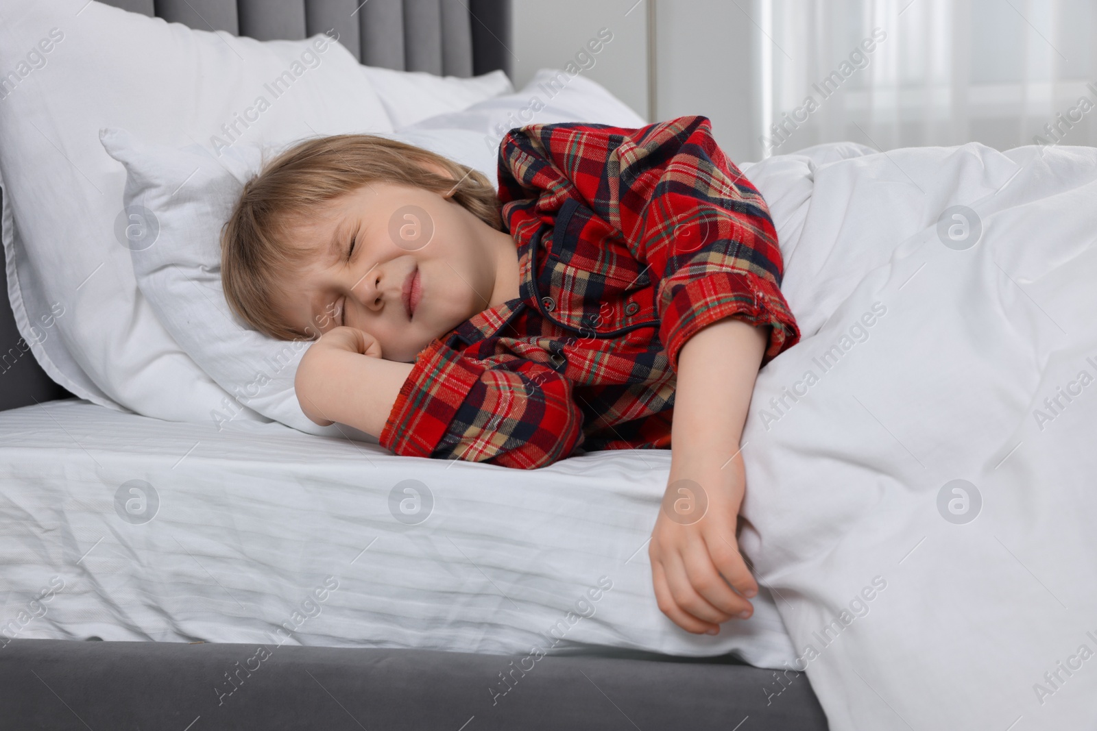 Photo of Little boy snoring while sleeping in bed at home