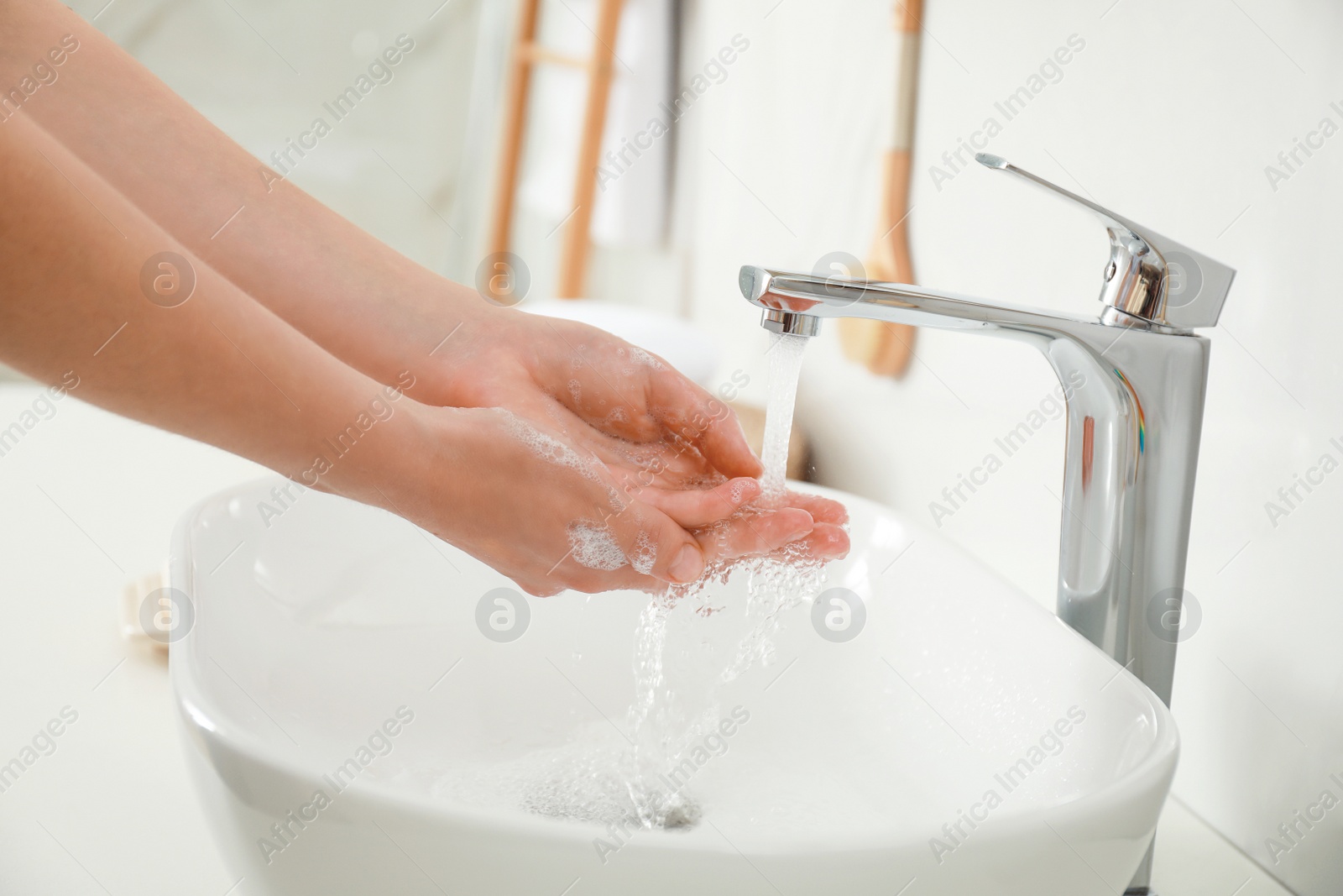 Photo of Woman washing hands indoors, closeup. Bathroom interior