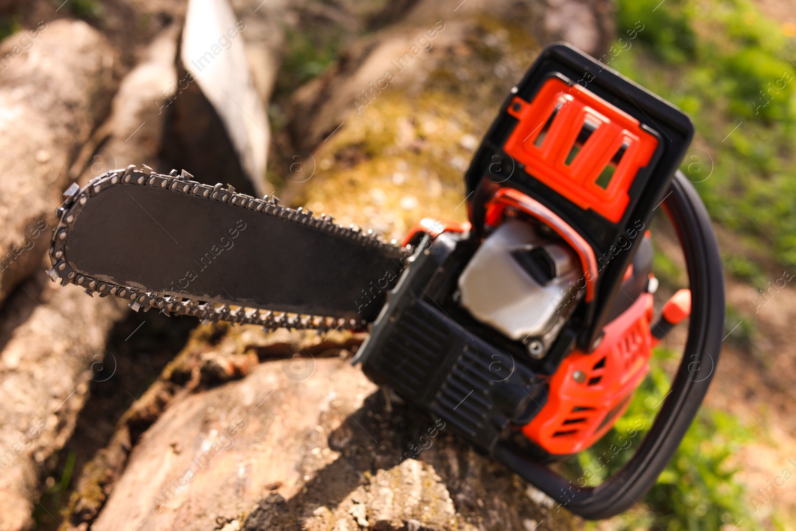 Photo of One modern saw on wooden log outdoors