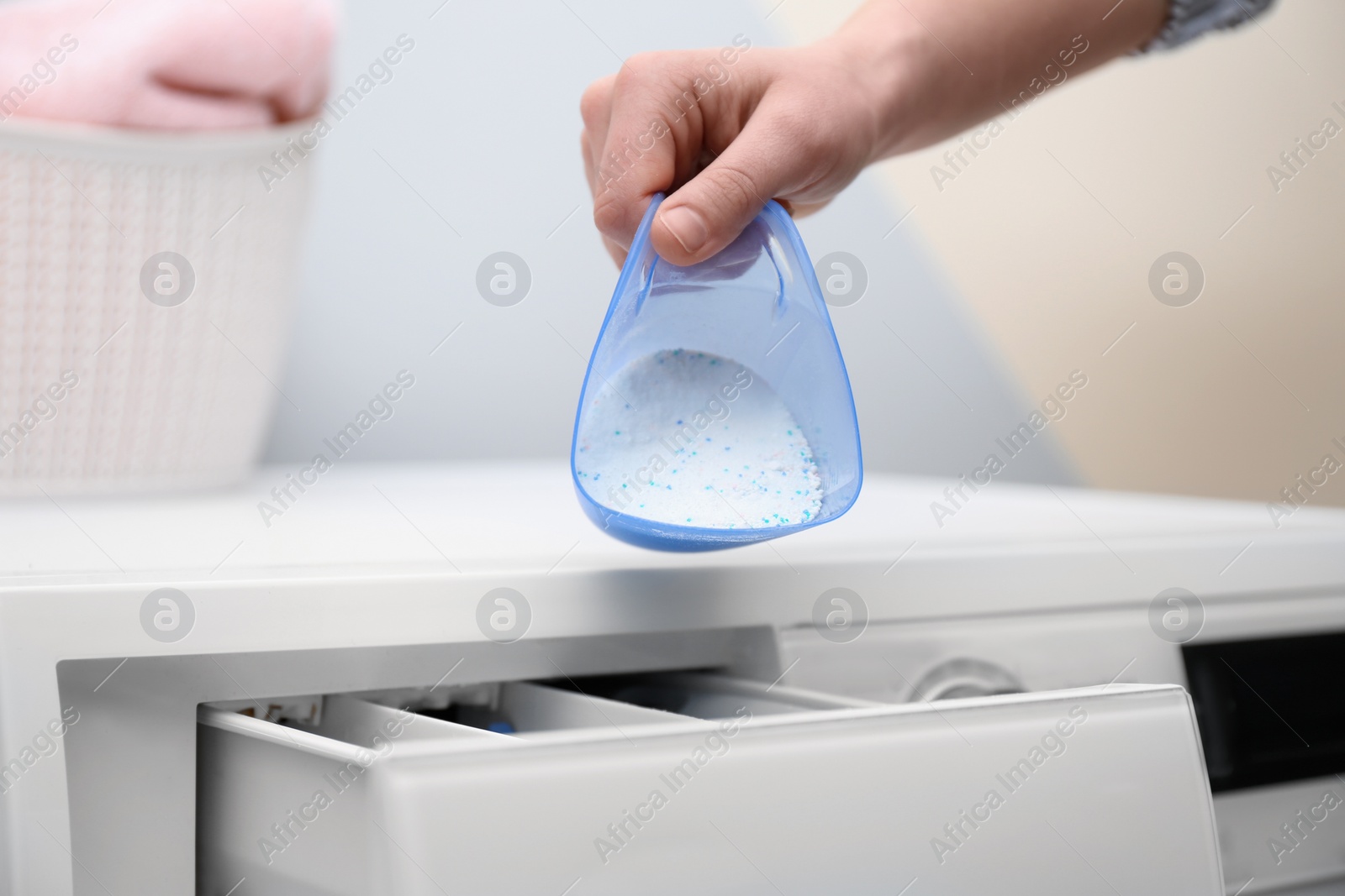 Photo of Woman pouring powder into drawer of washing machine indoors, closeup. Laundry day