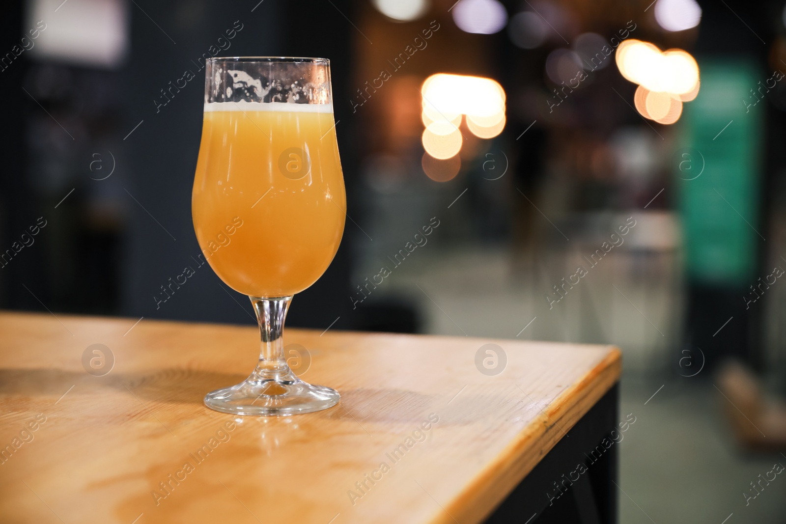 Photo of Glass of beer on wooden table in pub