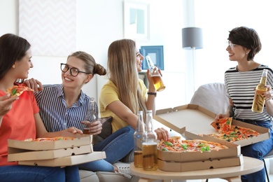 Young people having fun party with delicious pizza indoors