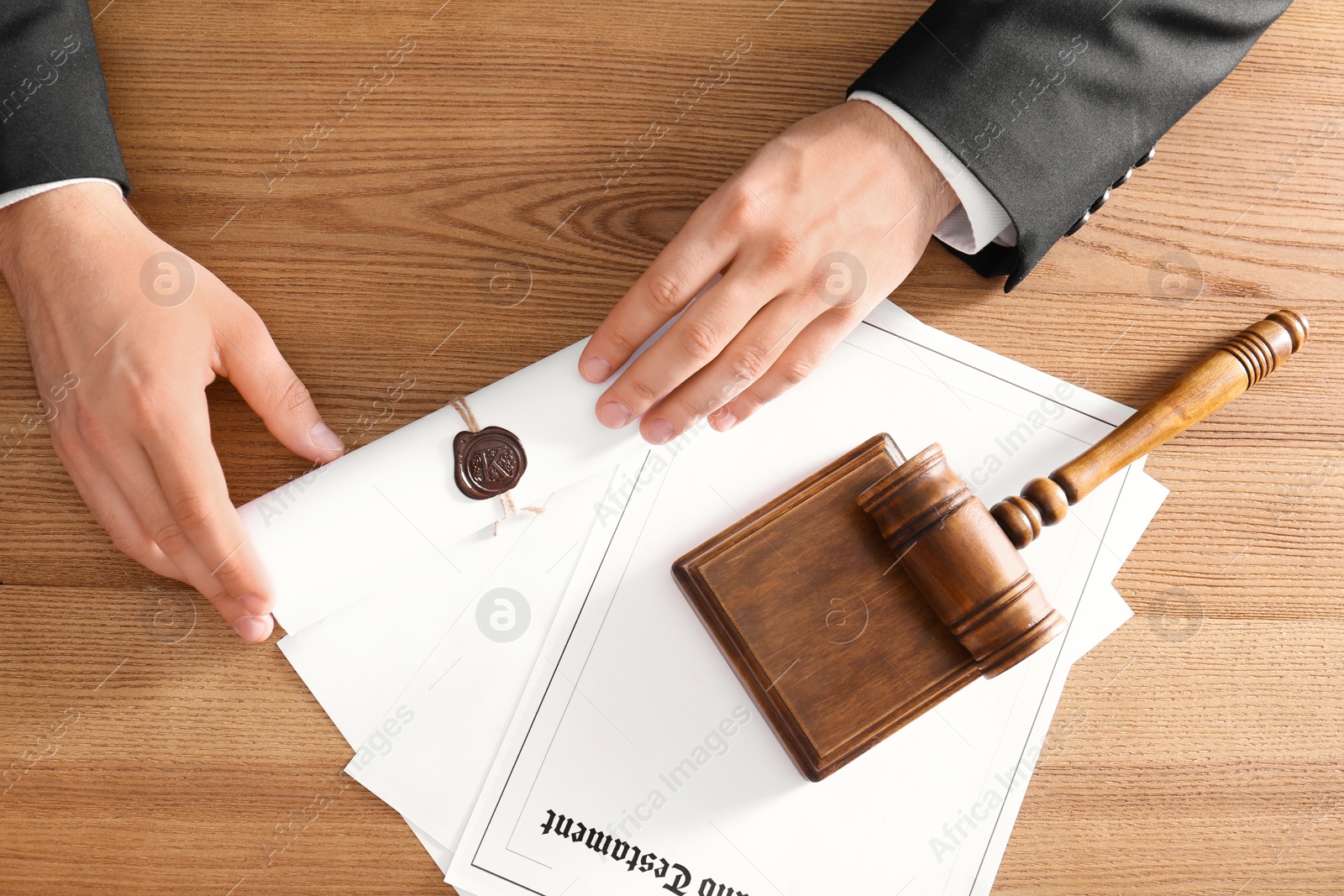 Photo of Male notary working at wooden table, top view