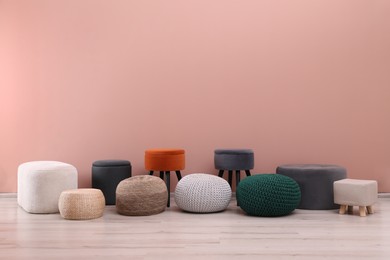 Photo of Different stylish poufs and ottomans near pink wall, space for text