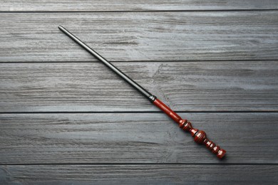 One old magic wand on grey wooden table, top view