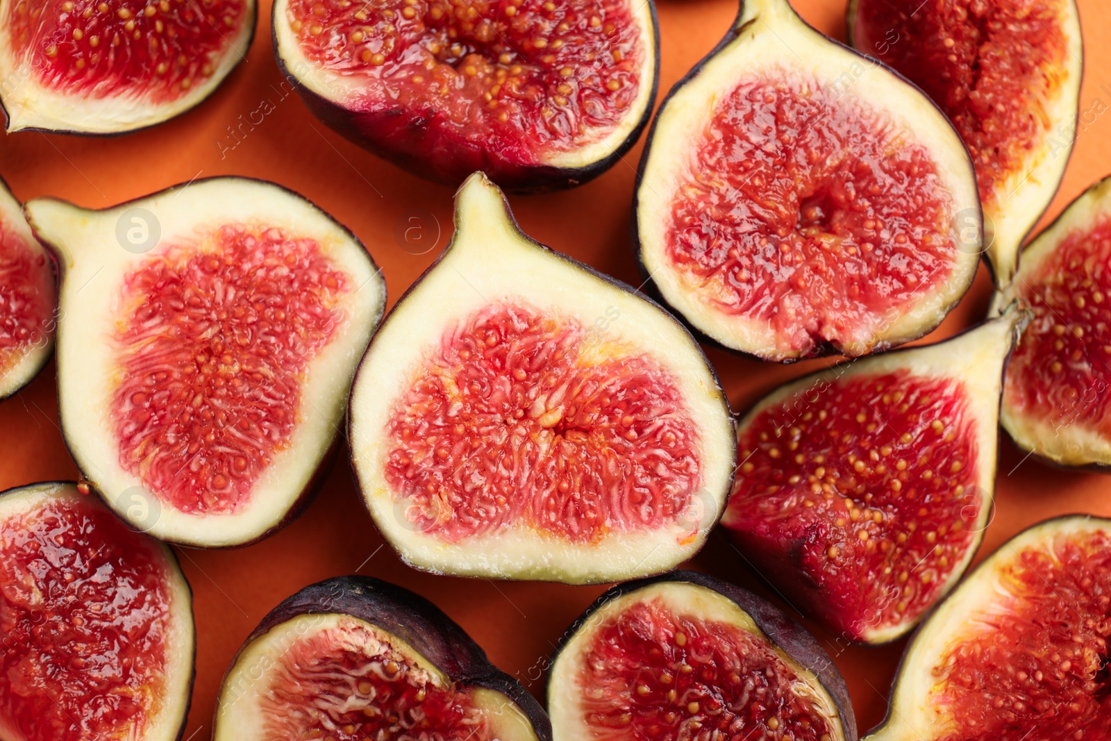 Photo of Delicious ripe figs on orange background, flat lay