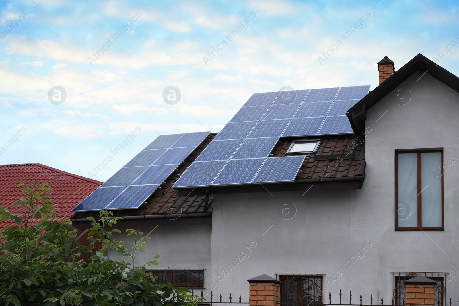 Photo of House with installed solar panels on roof. Alternative energy source