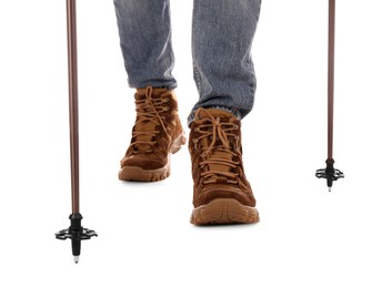 Photo of Man wearing stylish hiking boots with trekking poles on white background, closeup