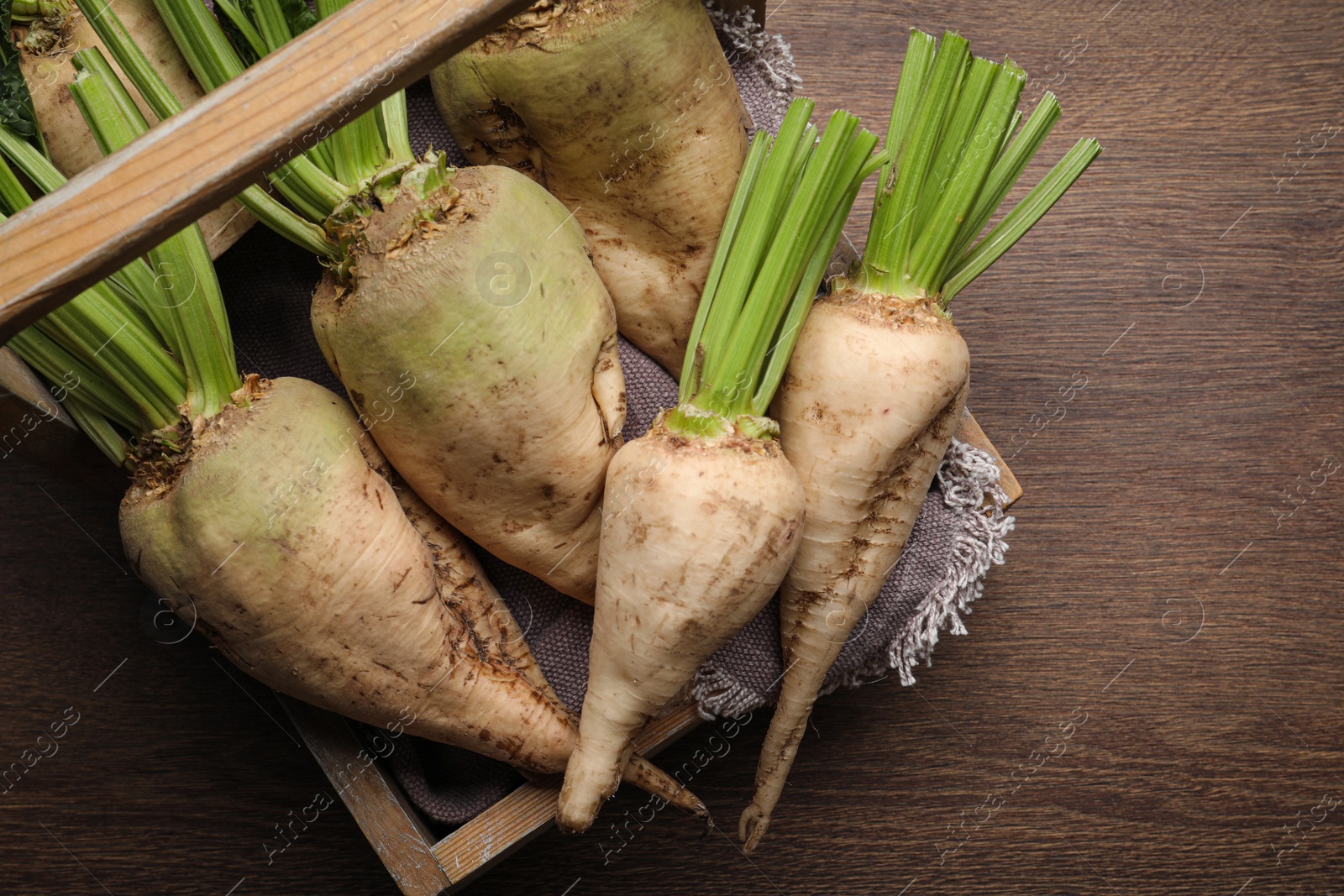 Photo of Basket with fresh sugar beets on wooden table, top view