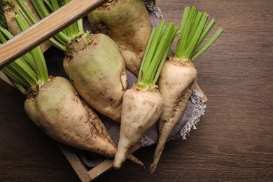 Photo of Basket with fresh sugar beets on wooden table, top view