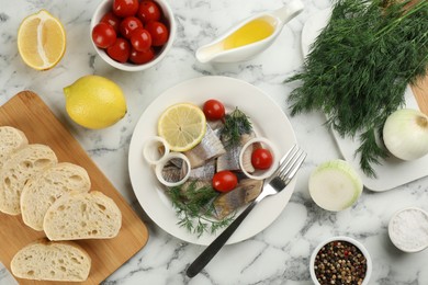 Sliced salted herring fillet served on white marble table, flat lay