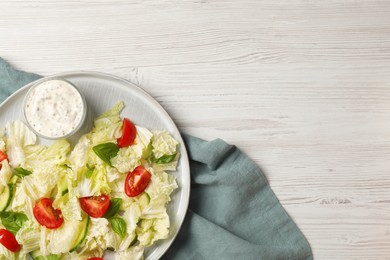 Photo of Delicious salad with Chinese cabbage, tomatoes, cucumber and dressing on white wooden table, top view. Space for text