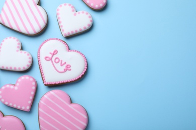 Photo of Delicious heart shaped cookies on light blue background, flat lay with space for text. Valentine's Day
